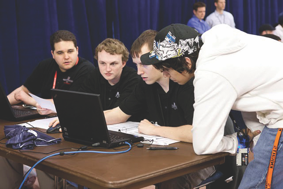 Cyber Battle Team looking at computer screen at Cybersecurity Competition