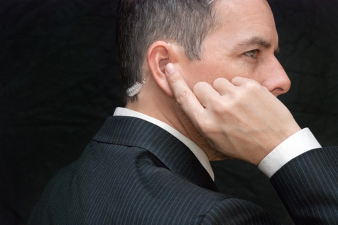 Stock photo of a Secret Service agent listening to ear piece