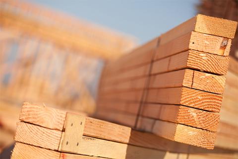 a stack of wood 2 by 4s demonstrates the need for managing construction materials shortages in 2021