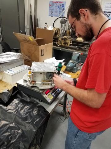 Photo of a Project Aether team member working on a satellite payload