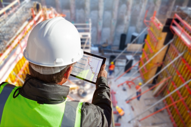  Construction manager looking at tablet at construction site symbolizing the role cybersecurity plays in construction