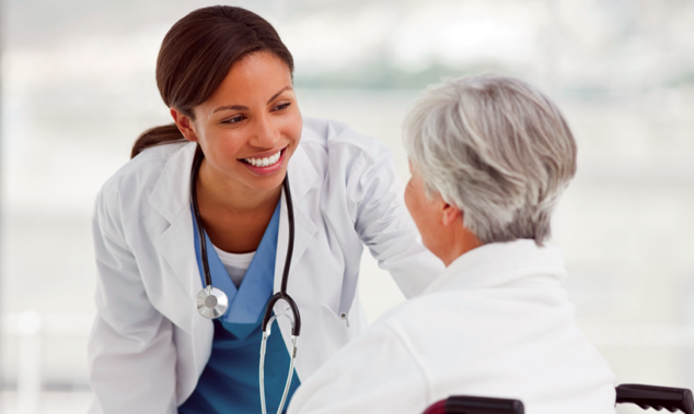 Doctor smiling at patient in wheelchair