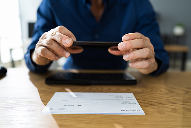 a man uses a mobile banking app for deposits which redefines role of cybersecurity in protecting critical infrastructure in the financial sector