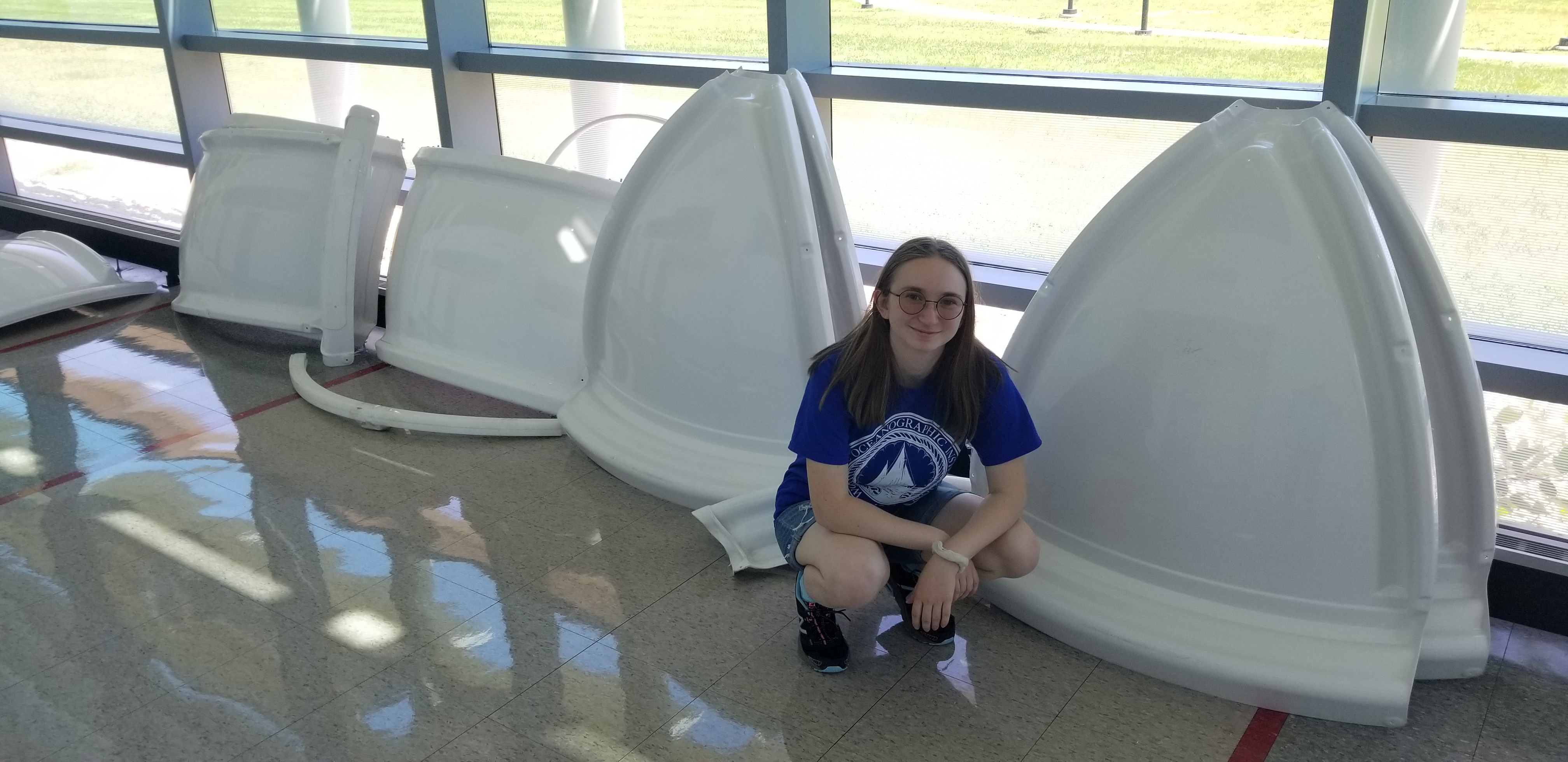 ALPHA Summer Intern Julianne Reese posing with observatory parts to be assembled