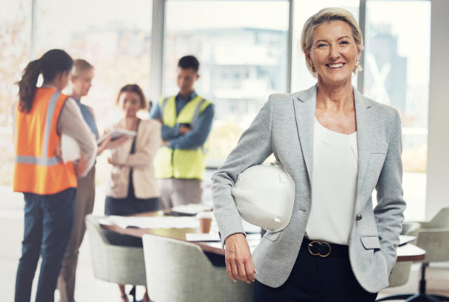construction manager smiling with workers in background