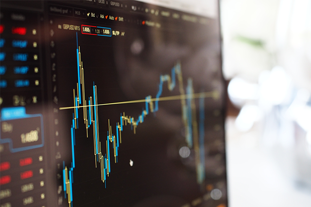 a close up of a desktop screen showing a volatile trend line shows the impact of cybersecurity breaches on stock prices