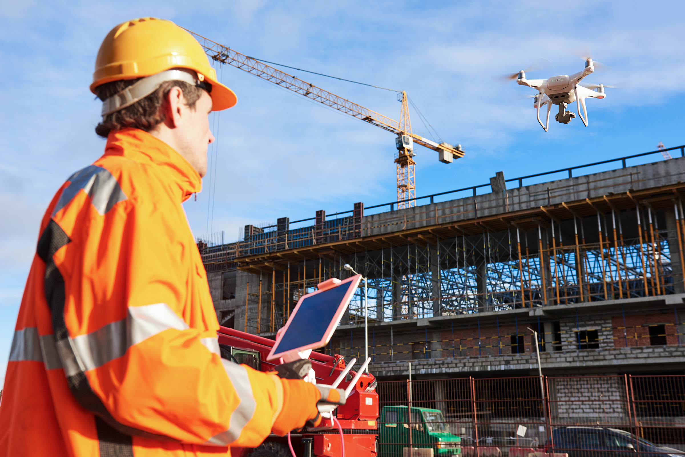 construction worker flying a drone on construction site