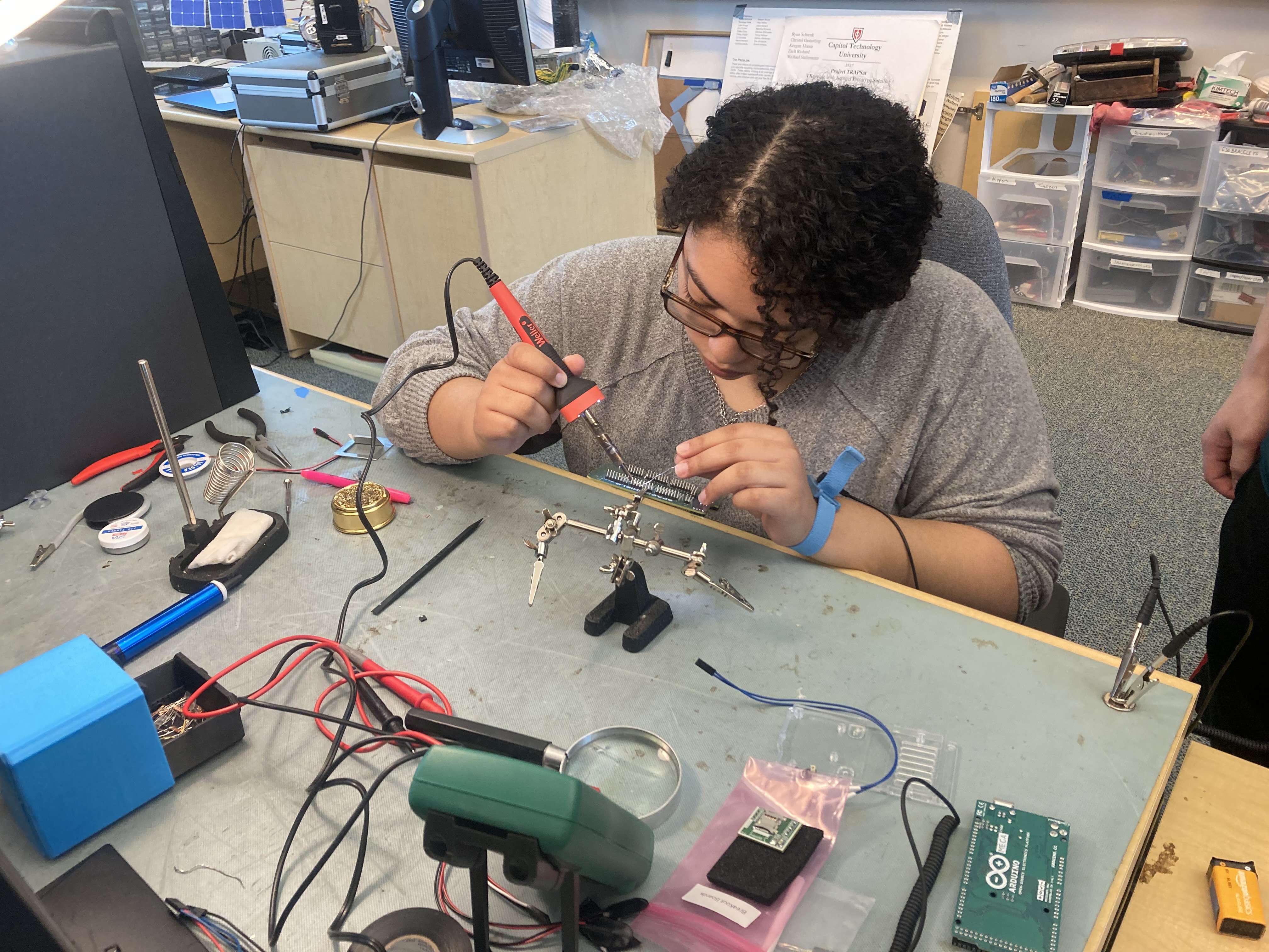 Recent graduate Princess Wilson works on soldering a paylod