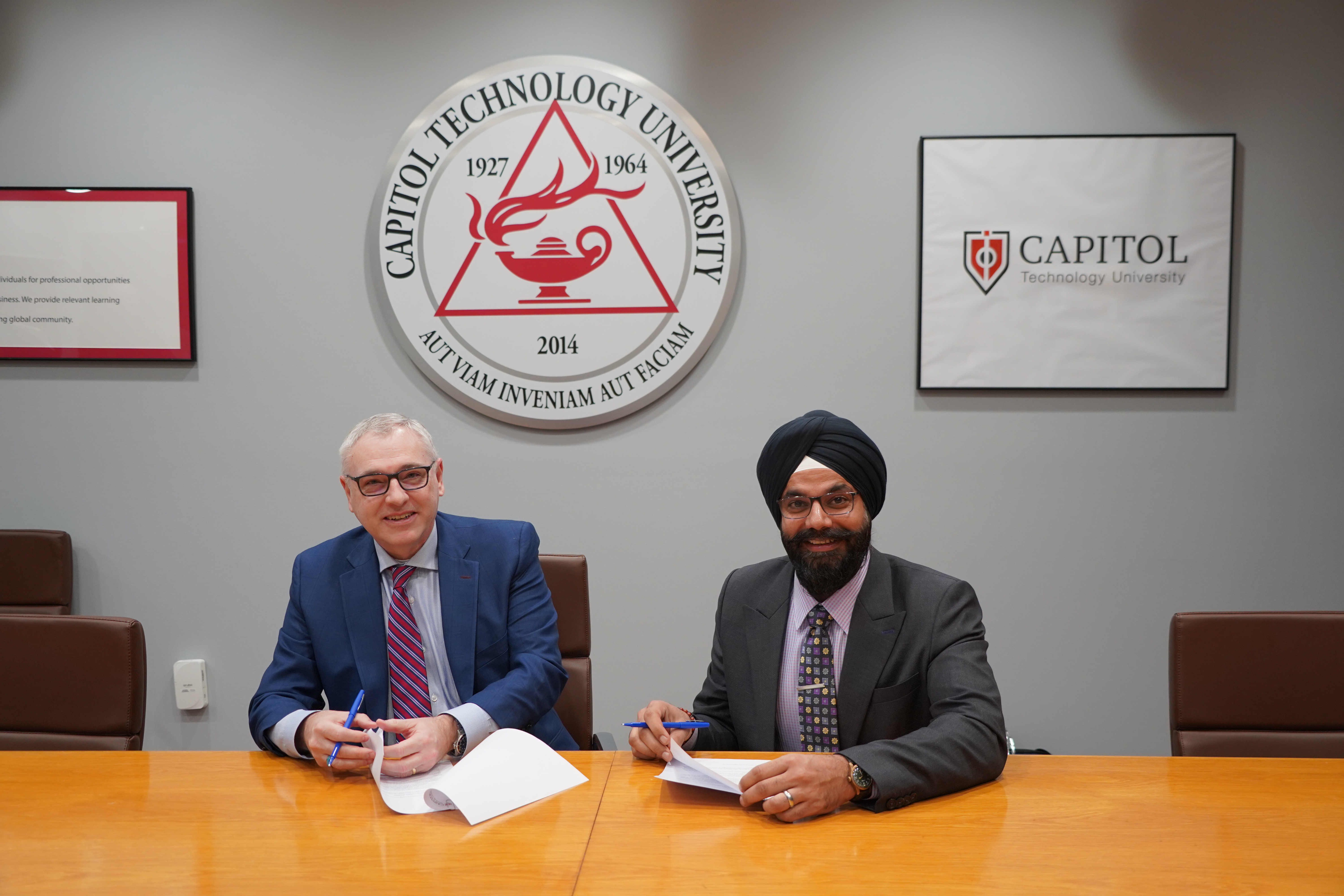 Bradford Sims of Capitol Tech and Gurpreet Singh of Infotrend signing an M.O.U.