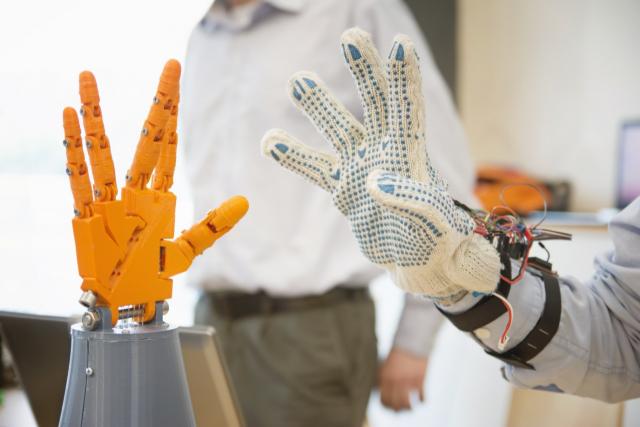 model hand and human hand wearing tech glove showing mechatronics in real life