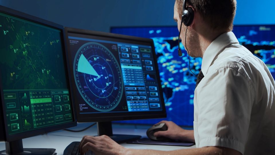 aviation professional working on multiple computer screens