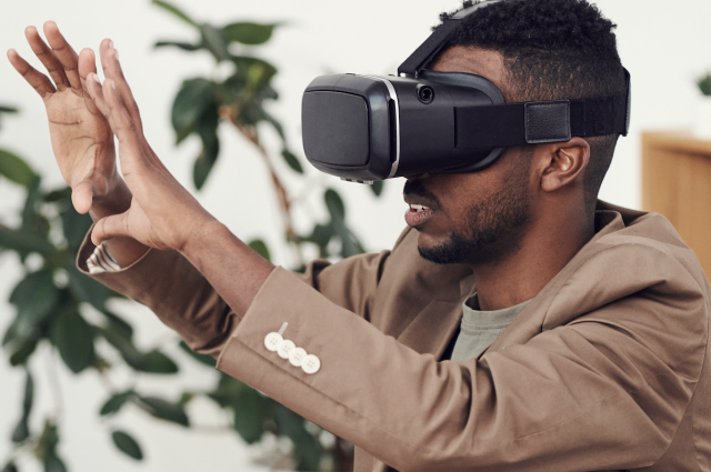 Man wearing VR headset with hands up