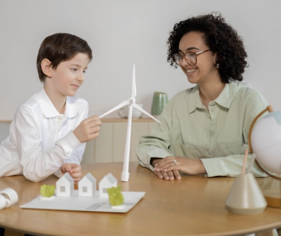 child and teacher building windmill model