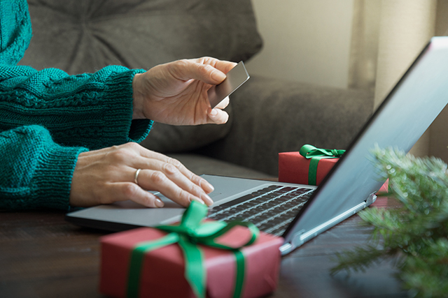hands holding a credit card hoping to ensure cyber safety while shopping online during holiday season
