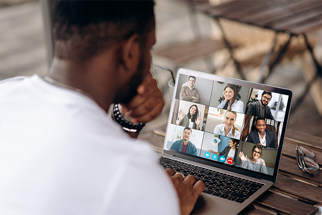 a man sits on Zoom with his peers demonstrating cybersecurity issues like zoom hacking of universities and schools