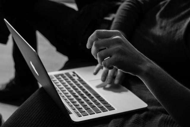 black and white image of a person on a laptop symbolizes cybersecurity and artificial intelligence chat bots