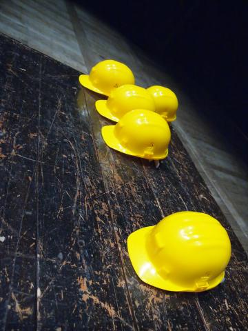 five hard hats lay on wood to symbolize the construction industry labor shortage