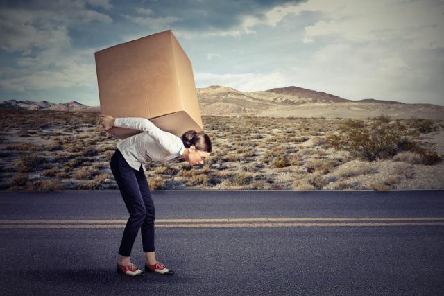 Woman carrying box on back on road