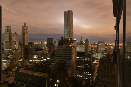 evening image of city buildings showing the need of construction management and cybersecurity to work together to protect power plants