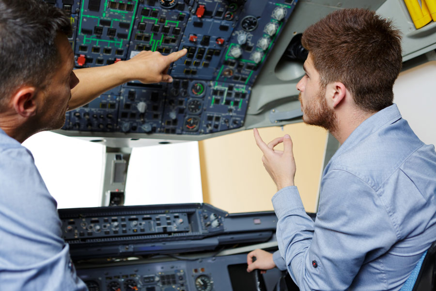 A student learning about the different controls in a commercial airline cockpit