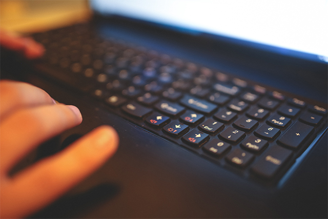 a close up of a hand on a laptop touchpad symbolizes how cybersecurity experts prevent cyber attacks