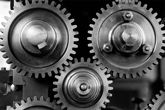 a close up of three metallic gears symbolize role of integrative thinking in mechatronics