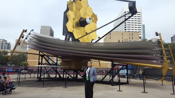 Scarlin Hernandez, Capitol Tech graduate, in front of the James Webb Telescope