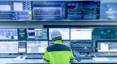 engineer sitting in front of wall of screens