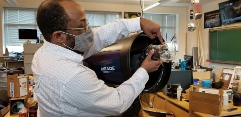 Professor Mabson demonstrates how camera and lens will be attached to the ALPHA telescope.