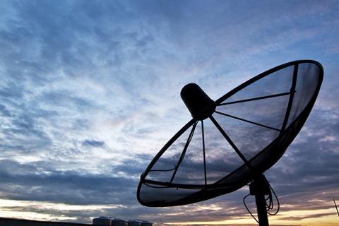 a close up image of remote sensing satellite technology against a cloudy sky