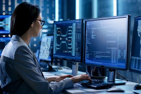 a woman working on a desktop in a cybersecurity lab symbolizes the top 10 cybersecurity skills