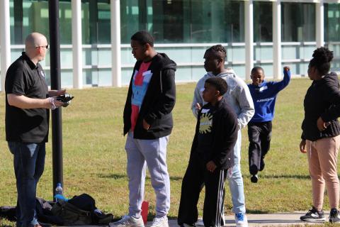 students gather around for a drone-flying lesson