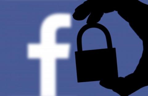 Facebook's logo appears behind the silhouette of a hand holding a lock symbolizing how an expanded cybersecurity red team can better protect networks