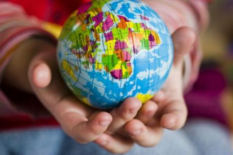 child holds small globe