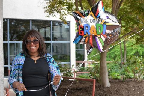 graduation attendee holding balloon